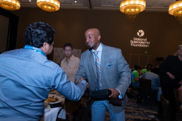 Kelley Hill shakes hands with someone in the audience