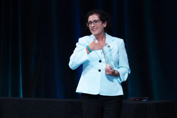 Dr. Carol Feghali-Bostwick holding her award on stage.